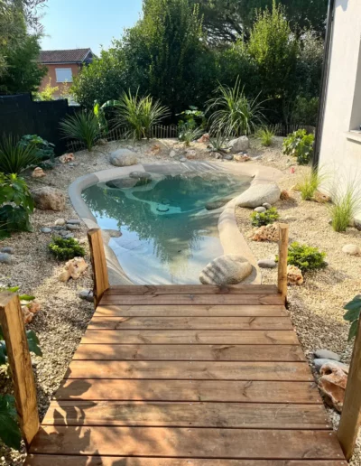 Une mini piscine lagon à La Brède avec un bel aménagement paysager par Cap'Paysages, paysagiste spécialiste de la piscine lagon en Gironde
